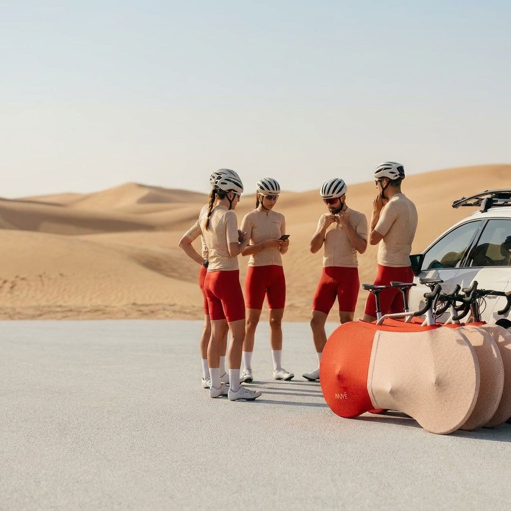 A group of Nuve NX2 protective gear in Hackney Wool colour range, red and herringbone two-tone, in a desert with cyclists and a car background.